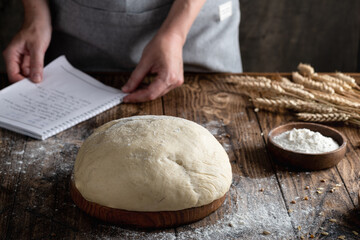 woman looking recipe and prepares dough