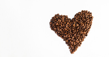 coffee beans laid out in the shape of a heart on a white scuffed background. Concept of a popular invigorating drink. selective focus.