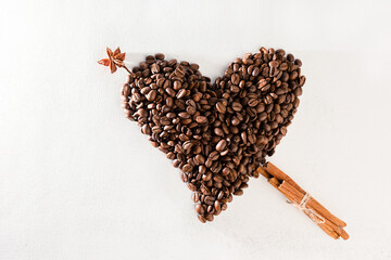 coffee beans laid out in the shape of a heart on a white scuffed background. Concept of a popular...