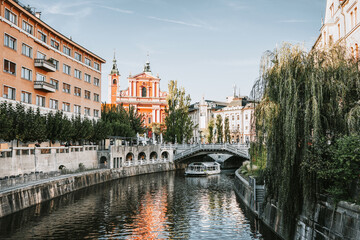 View of cityscape on canal of Ljubljana river, Tromostovje and Franciscan Church of Annunciation in old town of Ljubljana. Center of capital of Slovenia is Ljubljana. 
