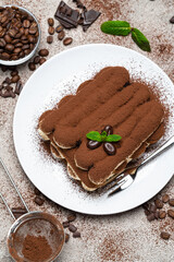 Classic tiramisu dessert on ceramic plate on concrete background
