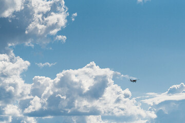 Fototapeta premium A small plane in front of giant clouds after the storm. The clouds break open and blue sky prevails.