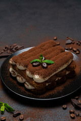 Classic tiramisu dessert on ceramic plate on concrete background