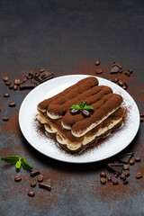 Classic tiramisu dessert on ceramic plate on concrete background