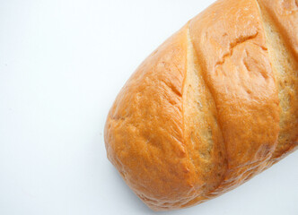 A loaf of fresh white bread, with a crust, on a light background. Bread texture, homemade cakes, cooking, breakfast, bakery. Rise in price, raise food prices