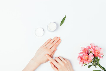 Top view female hands applying moisturizer cream