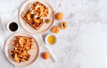 belgian waffles with fresh apricots and honey on white background top view flat lay