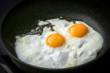 Fried eggs from two eggs are fried in a pan