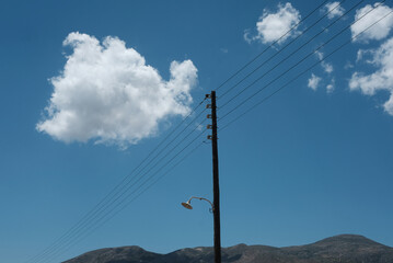 power line against blue sky with white clouds 