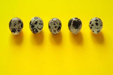 Quail eggs on a yellow background