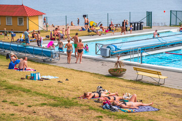 People sunbathing at a swimming pool at a resort in Sweden