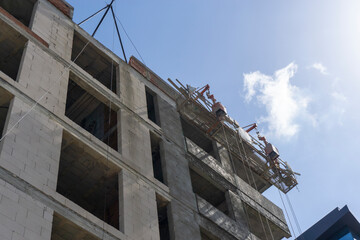 Construction workers plaster the facade of the house. Application Of Facade Plaster. Elevation of the building. Four workers are plastering the facade of the building.