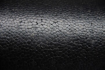 Black polyfoam close up, texture of black polyfoam background.