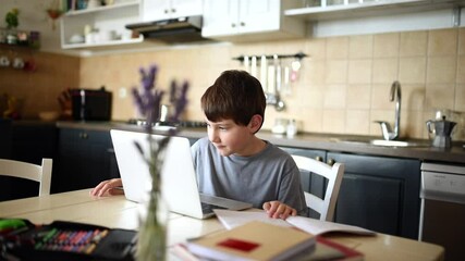 Boy doing homework in his kitchen