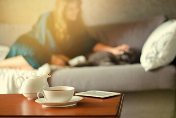 Cozy home interior with teapot, cup of tea and eBook