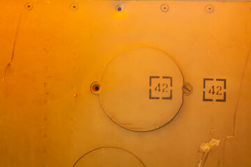 Number 42 on a metal hatch. Metal on the surface of the rocket. Background for a military theme with old military armor texture with rivets.