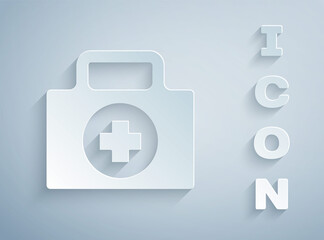 Paper cut First aid kit icon isolated on grey background. Medical box with cross. Medical equipment for emergency. Healthcare concept. Paper art style. Vector Illustration.