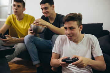 teenager boys having fun playing games on console at home