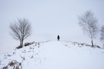 winter landscape with snow and a women behind trees