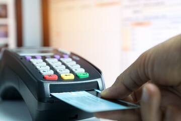 Insert Credit card POS terminal machine,closeup paying by credit cards in café. Focus on man hands...