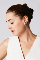 portrait studio de profil d'une femme quarantenaire élégante portant un chignon chic  © mariesacha