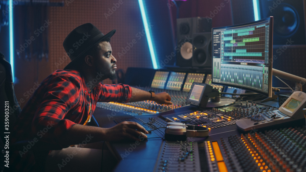 Fototapete stylish audio engineer working in music recording studio, uses mixing board and software to create m