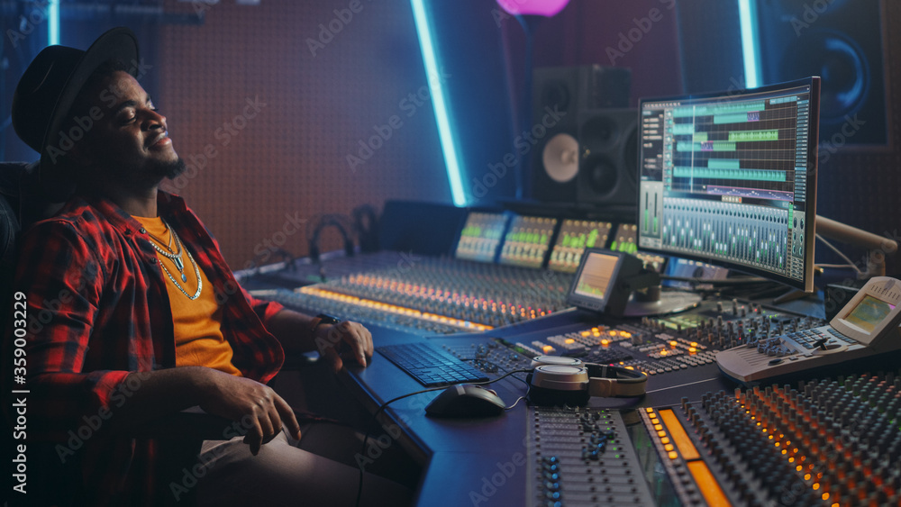 Poster energetic audio engineer / producer chill in music recording studio, mixing tracks on control desk a