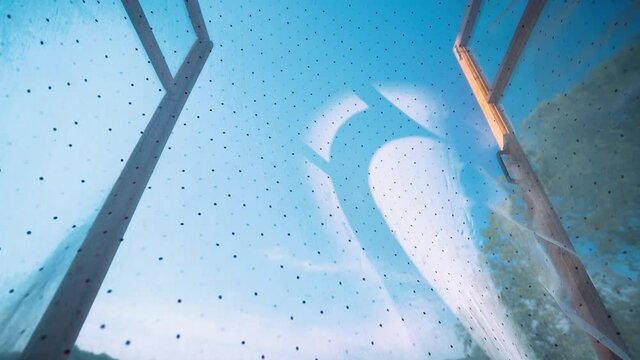 A curtain develops in the wind. Open Window Blue Sky. Slow motion