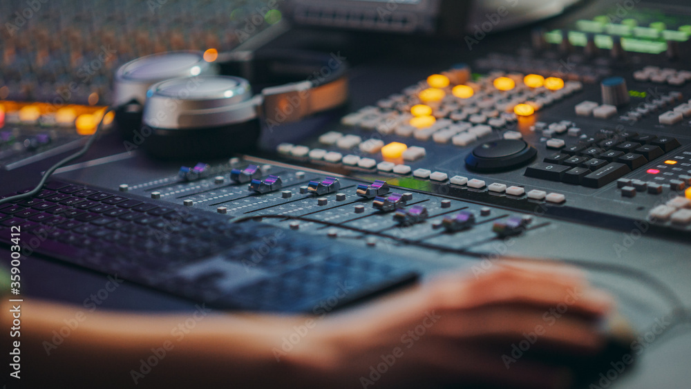Fototapete close up shot of hands of audio engineer and producer working in music recording studio, uses mixing