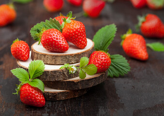 Fresh raw organic strawberries with leaf on timber plate on wooden background. Macro