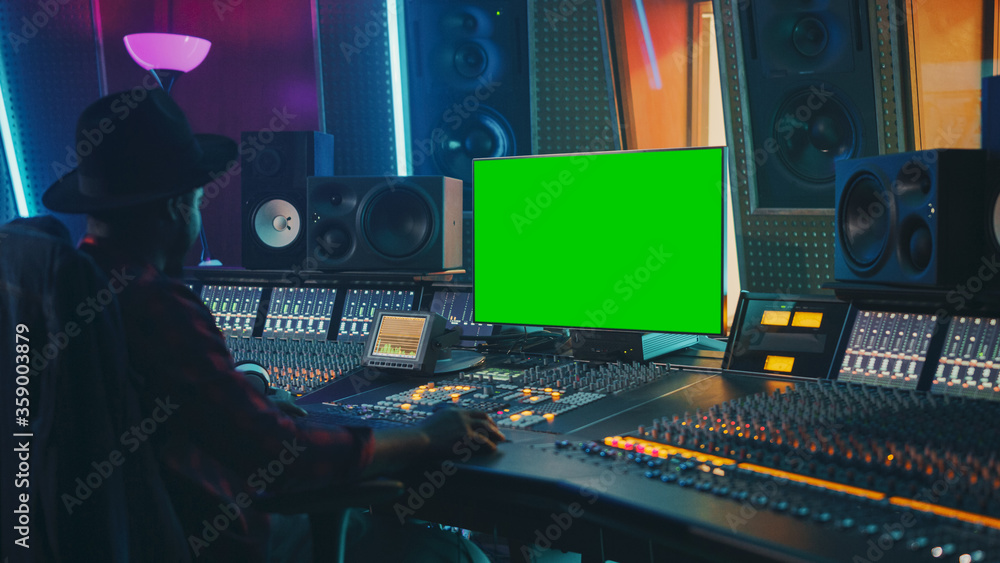 Aufkleber stylish audio engineer / producer working in music record studio, uses green screen chroma key compu