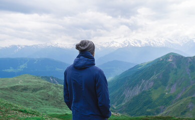Fototapeta na wymiar A man looks at the mountains. Caucasus mountains, Georgia, mountain Svaneti.