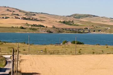 landscape with the lake of Conza della Campania and cultivated fields on the hill. Campania,...