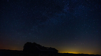 Starry filled sky with an abandoned barn in the foreground
