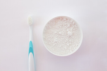 Close-up white tooth powder in an open jar and toothbrush with blue pen on white background. Home Whitening and Hygiene
