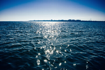 blue sea with glare of the sun, seashore