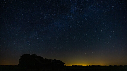 Starry filled sky with an abandoned barn in the foreground