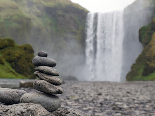 Zen Stone stacks or cairn near waterfall Skogafoss, Iceland. Balanced pebbles pyramid. Concept of...