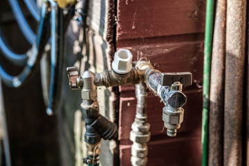 A water faucet made by yourself from the remains of metal, sometimes rusty, pipes and old taps.
