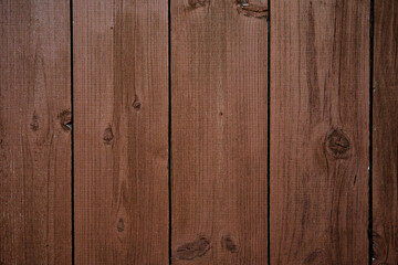 Wooden background from old boards arranged vertically and painted with brown-red paint.