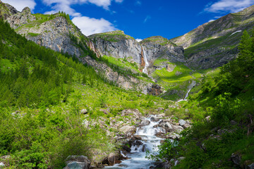 Naklejka na ściany i meble Scenic waterfall and mountain river on the italian Alps. Tourism destination hiking outdoors activity. Pis waterfall near Torino, Piedmont, Italy