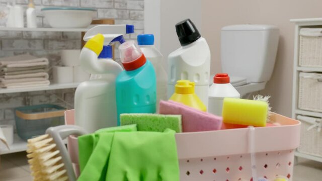 Basket with cleaning supplies in bathroom