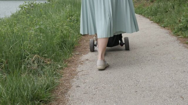 Mother walks while pushing stroller slow-mo video