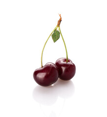 fresh cherry berries with a green leaf isolated on a white background