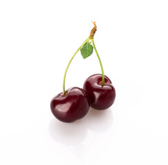 fresh cherry berries with a green leaf isolated on a white background