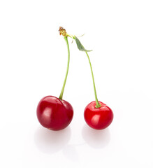 fresh cherry berries with a green leaf isolated on a white background