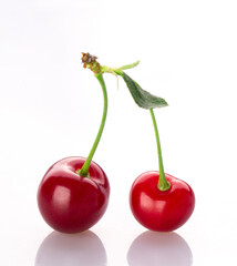 fresh cherry berries with a green leaf isolated on a white background