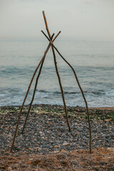 Branches teepee on the beach