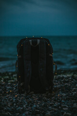 Backpack with lights on the seashore in the evening