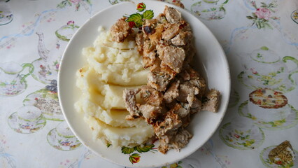 slices of roast pork and mashed potatoes on a plate